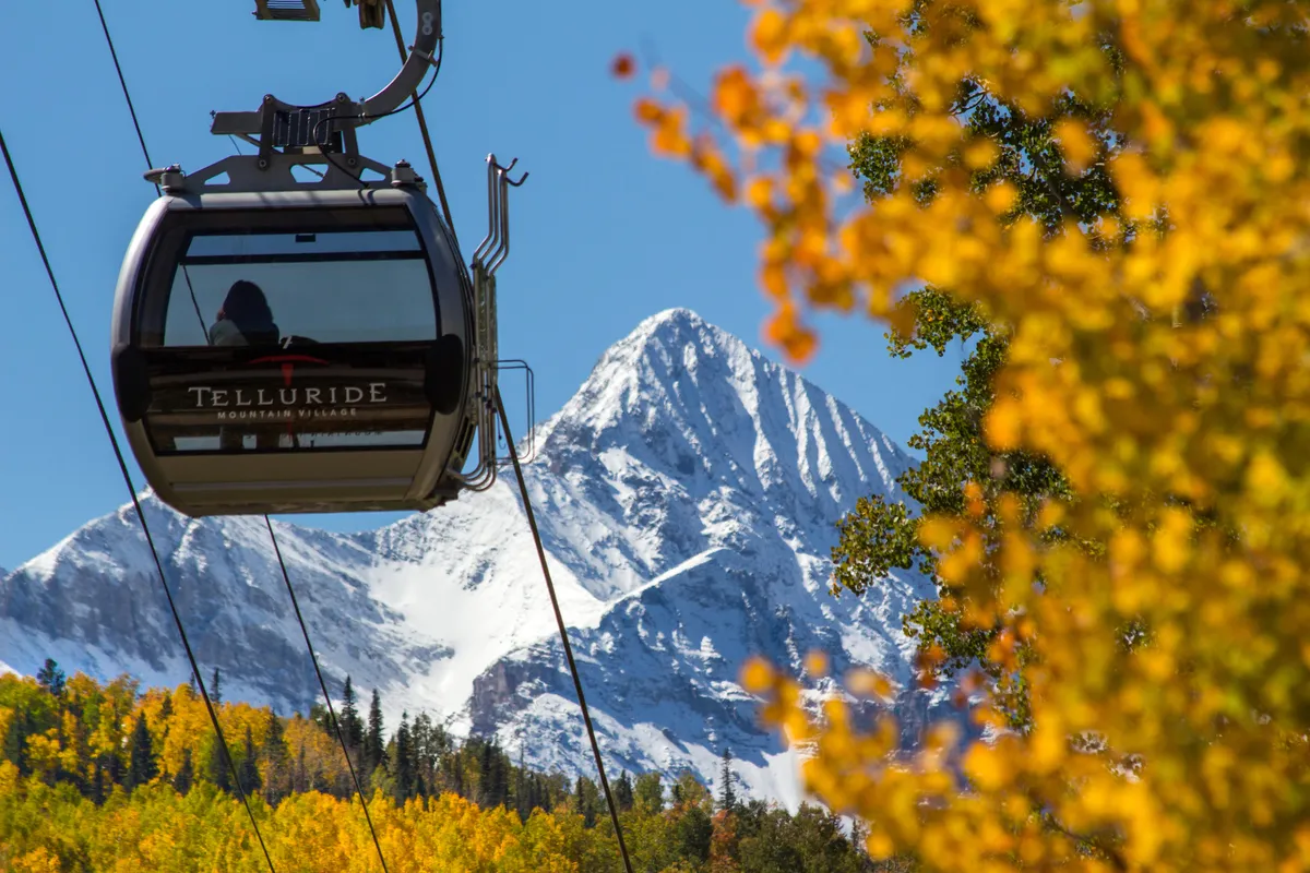 This image features Telluride’s iconic gondola against a backdrop of snow-capped mountains and vibrant autumn foliage. The gondola is the key access point to the ski slopes and a central feature of local adventure, directly reflecting the section’s mention of being just steps from the gondola and Lift 8.