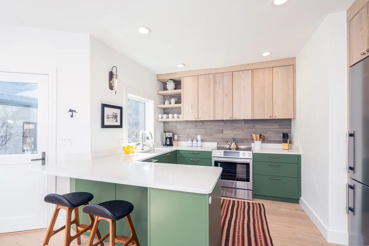 A welcoming, functional kitchen with a central island, bar stools, a prominent stove, and open shelves lined with dishes. The space hints at family gatherings and culinary activity, with enough room for sharing recipes and celebrating together.